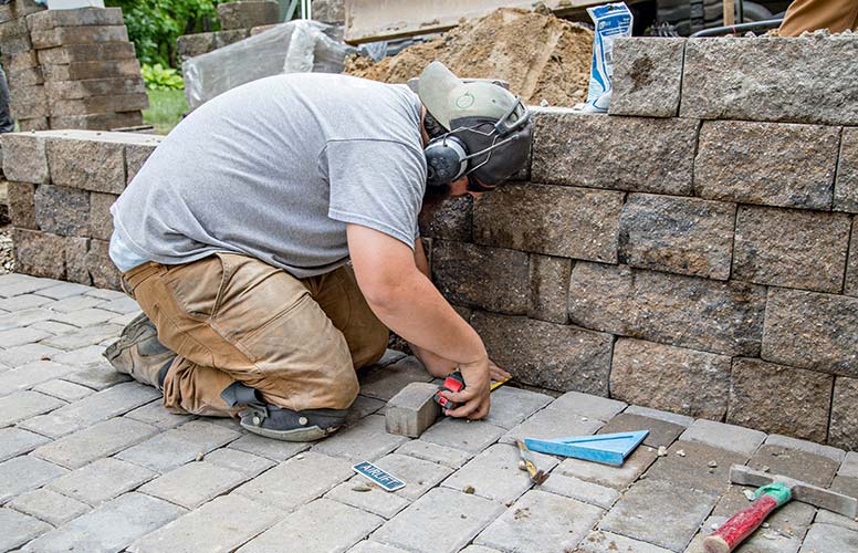 A man is working on a brick wall.